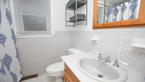 a bathroom with a sink and a toilet and a mirror at Cape Bay Cottage in North Cape May