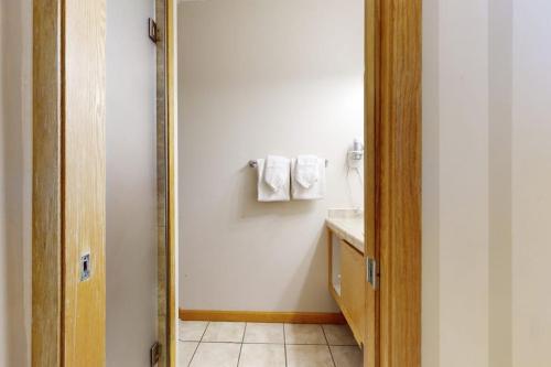 a bathroom with a mirror and a sink with towels at River Bank Lodge 2919 in Keystone