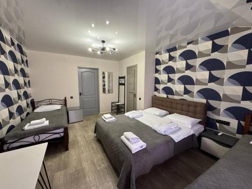 a bedroom with two beds and a geometric wall at Готель Гайсин «Тіроль» in Haysyn