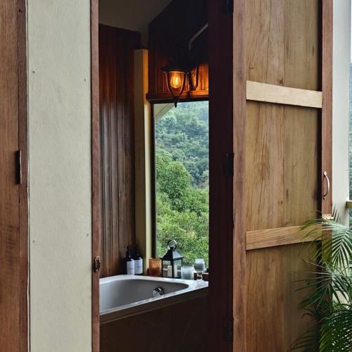 a bathroom with a bath tub and a window at U Garden in Ban Huai Khai