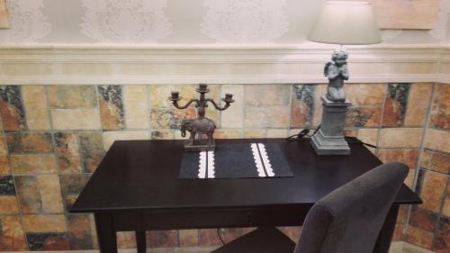 a black table with a lamp and a chair at Art Apartments in Poznań