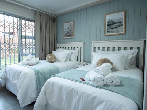 two beds with towels and a child sitting on them at Oliverio Seaside Living in Sedgefield