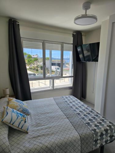 a bedroom with a bed and a large window at Apartamentos Casa Albino in Sanxenxo