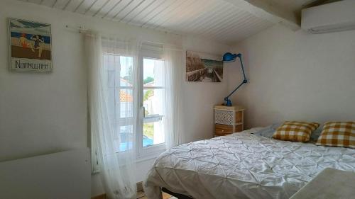 a bedroom with a bed and a window at Maison Barbâtre in Barbâtre