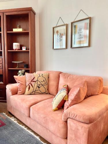 a brown couch with pillows in a living room at Metro Suites in Tirana
