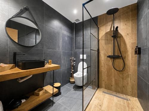 a bathroom with a shower and a toilet and a mirror at Olea Luxury Living in Nea Fokea