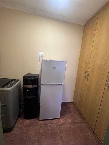 a kitchen with a white refrigerator and a trash can at Kalahari Hotel in Olifantshoek