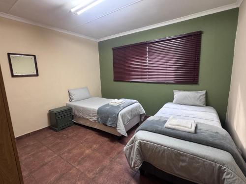 a room with two beds and a window in it at Kalahari Hotel in Olifantshoek