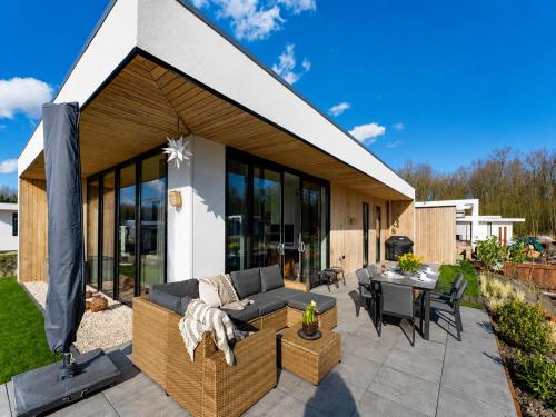 a patio with a couch and a table at Harderwold Villa - 412 in Zeewolde