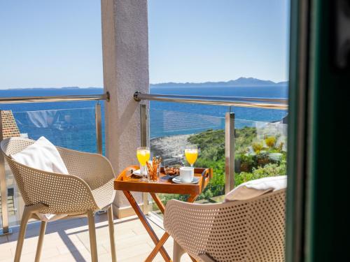 a balcony with a table and two glasses of orange juice at Villa Lavanda Korčula in Zavalatica