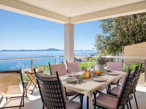 a table on a balcony with a view of the ocean at Villa Lavanda Korčula in Zavalatica