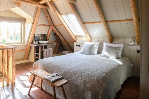 a bedroom with a large bed in a attic at Walingsuites in Holwerd