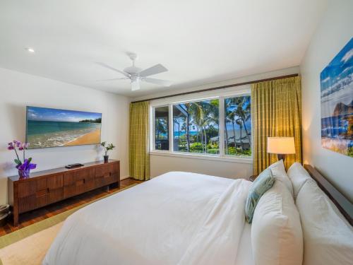 a bedroom with a bed and a large window at 3-Bed Villa 309 at Turtle Bay in Kahuku