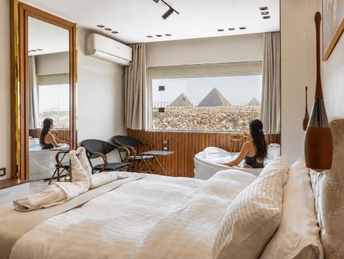 a hotel room with a bed and a view of the pyramids at Shiny Pyramids Boutique Hotel in Cairo