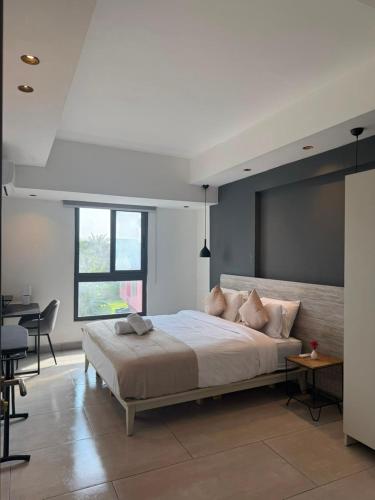 a bedroom with a large bed and a desk in it at QUATTRO-Sky Suites in Accra