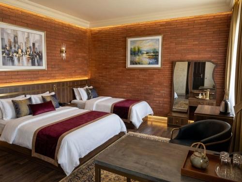 a hotel room with two beds and a mirror at Anadolu Hotel & Restaurant & Spa in Batumi