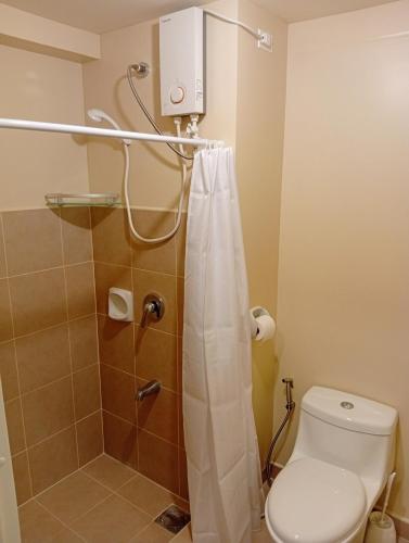 a bathroom with a toilet and a shower at Avida Towers Riala, Tower 5 in Cebu City