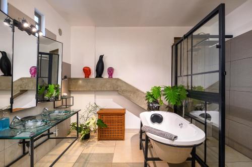 a bathroom with a tub and a sink and some plants at Villa Mauritius - Designer Private Studios in Pointe aux Sable