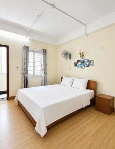 a bedroom with a large white bed in a room at Oriio Hotel in Cat Ba