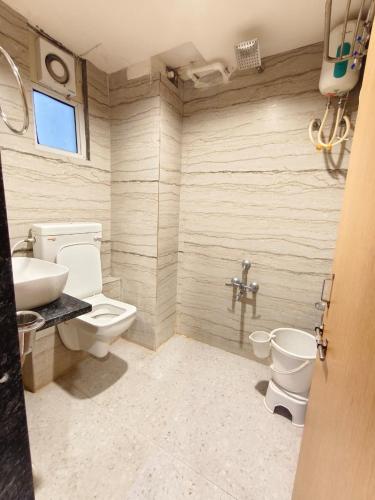 a bathroom with a toilet and a sink at Hotel Royal Relax in Gandhinagar