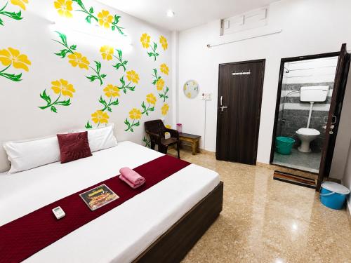 a bedroom with a bed with flowers on the wall at Trip Kashi Guest House in Varanasi