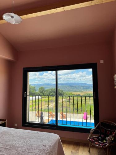 a bedroom with a large window with a view at La Grange Guesthouse in Beausemblant