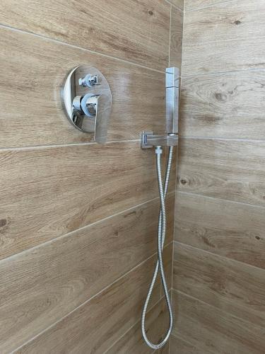 a shower with a hose attached to a wooden wall at Aria Case Vacanze - Frumento in Favignana