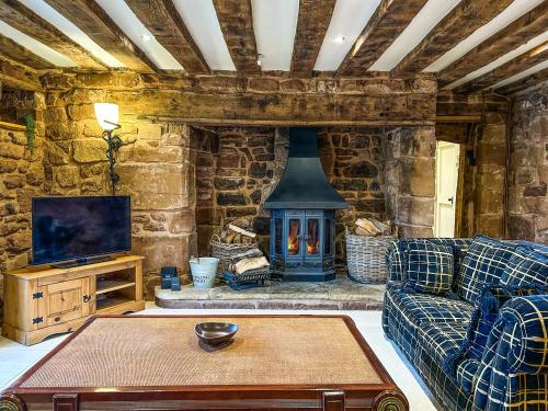a living room with a couch and a fireplace at Ye Olde Stone House in Sutton Coldfield