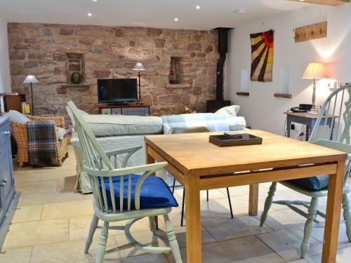 a living room with a table and chairs and a couch at The Barn in Greystoke