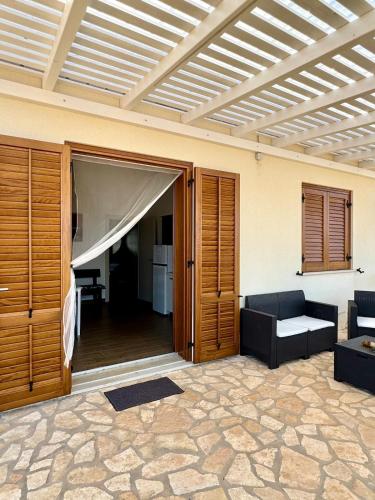 a living room with a couch and an open door at Aria Case Vacanze - Frumento in Favignana