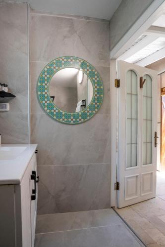 a bathroom with a mirror and a white door at בצל הדקל in Bet Leẖem HaGelilit