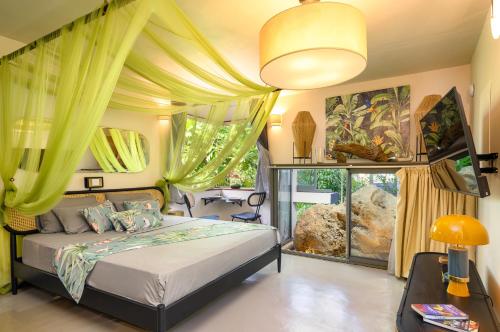 a bedroom with a bed with yellow curtains at Villa Mauritius - Designer Private Studios in Pointe aux Sable