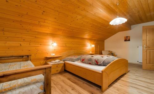 a bedroom with two beds in a wooden room at Lüch de Tor in San Martino in Badia