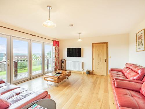 a living room with two couches and a table at Paradise in Cinderford