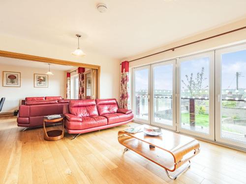 a living room with a red couch and a table at Paradise in Cinderford