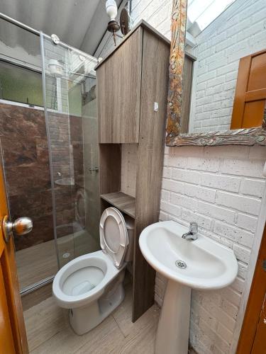a bathroom with a toilet and a sink at Cabaña entre Cafetales in Manizales