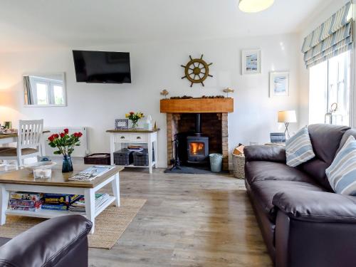 a living room with a couch and a fireplace at The Bay - The Bolthole in Reighton