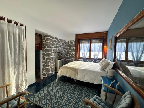 a bedroom with a bed and a stone wall at Villa Planca by Gottschalk in Fiumelatte