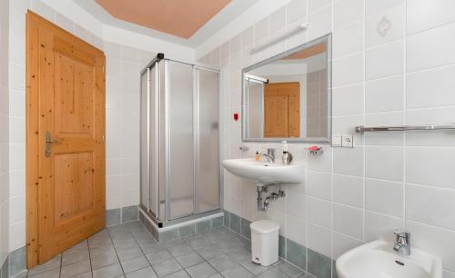 a bathroom with a sink and a shower and a toilet at Lüch de Tor in San Martino in Badia