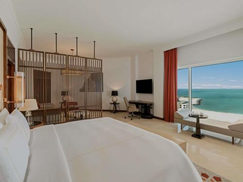 a bedroom with a bed and a view of the ocean at Rixos Marina Abu Dhabi in Abu Dhabi