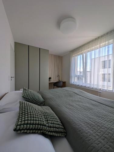 a bedroom with a large bed with a large window at Apartment VIEW 27 in Olomouc