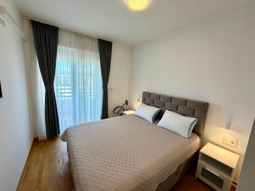 a bedroom with a large bed and a window at Apartmants City Love in Podgorica