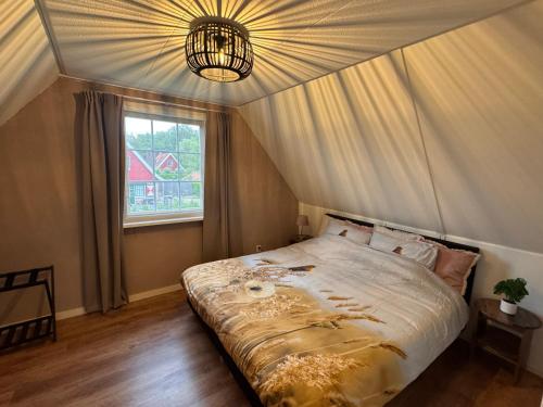 a bedroom with a large bed in a tent at Vakantiewoning Uutbloazen in Lievelde