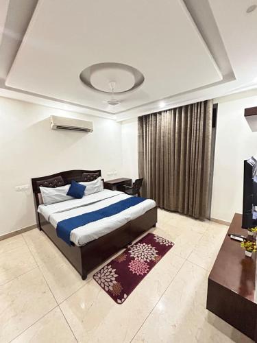 a bedroom with a large bed and a desk and a table at Utk 3 in Panchkula