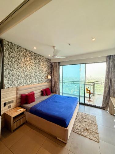 a bedroom with a large bed and a large window at Nova Spira in Noida