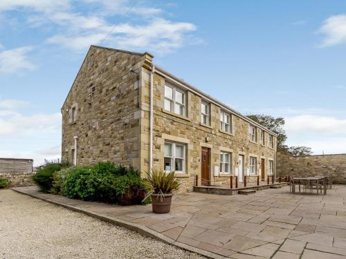 a stone building with a patio in front of it at Orchard Sands in Beadnell