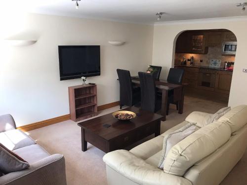 a living room with two couches and a tv at Orchard Sands in Beadnell