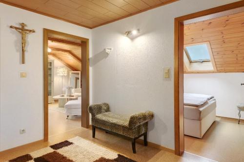 a bedroom with a bed and a chair in a room at Bayernseele - Bayerwald in Spiegelau