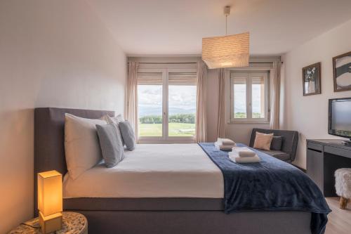 a bedroom with a large bed with a window at Amanthos Living Nyon in Duillier