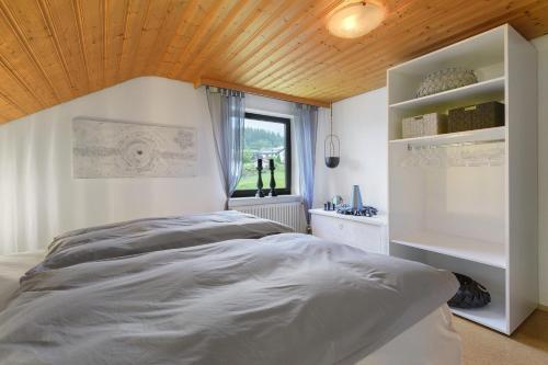 a bedroom with a large bed with a wooden ceiling at Bayernseele - Bayerwald in Spiegelau